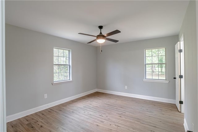 empty room featuring ceiling fan, plenty of natural light, and light wood-type flooring