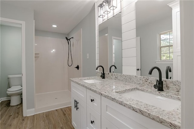 bathroom with vanity, toilet, wood-type flooring, and walk in shower