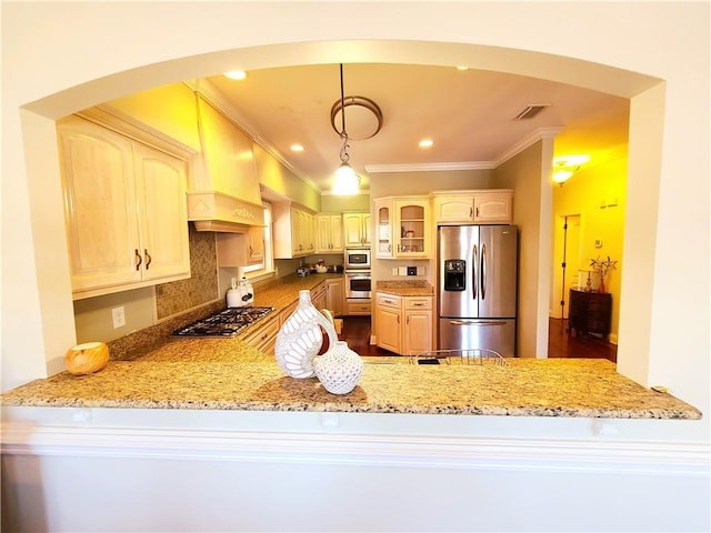 kitchen with light stone countertops, ornamental molding, decorative light fixtures, appliances with stainless steel finishes, and custom exhaust hood