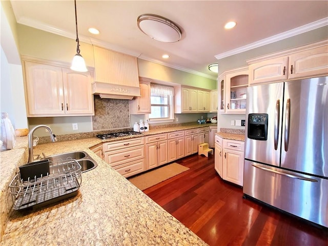 kitchen featuring light stone counters, stainless steel appliances, crown molding, sink, and hanging light fixtures