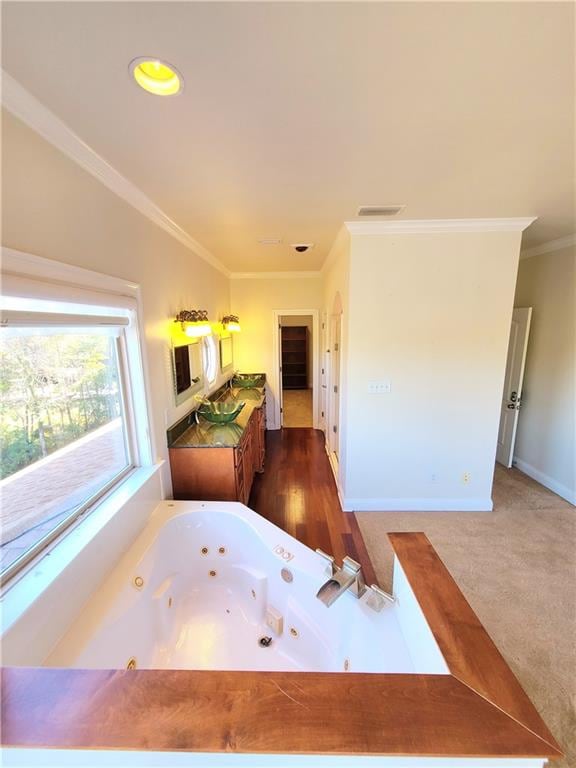 bathroom with hardwood / wood-style flooring, a bathtub, and ornamental molding