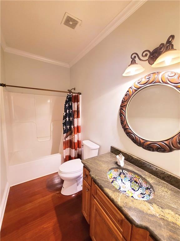 full bathroom with vanity, hardwood / wood-style floors, shower / bath combo, and ornamental molding