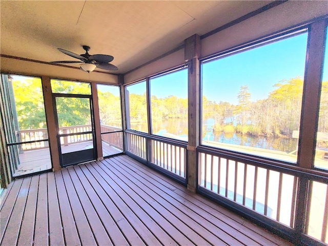 unfurnished sunroom featuring ceiling fan and a water view