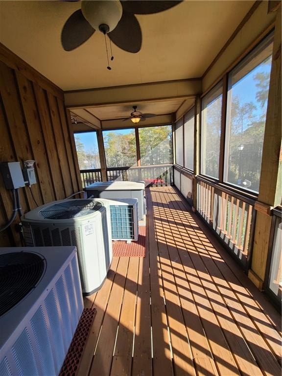 sunroom featuring ceiling fan, plenty of natural light, and a hot tub