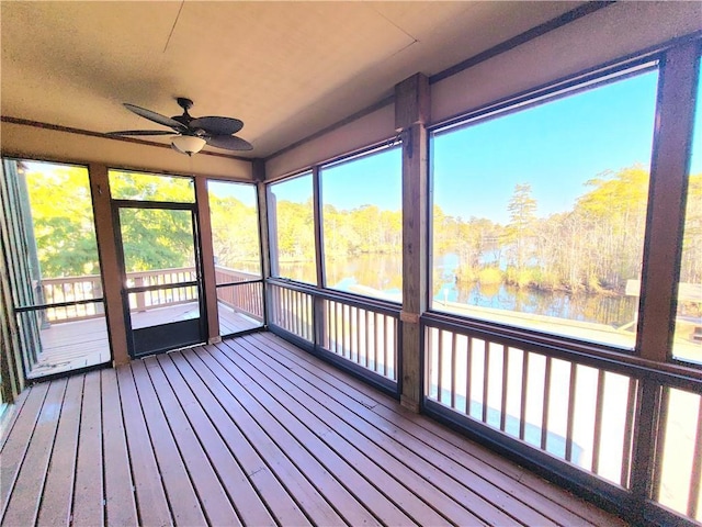 unfurnished sunroom with a water view and ceiling fan