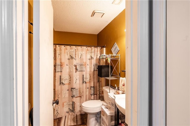 full bath featuring toilet, curtained shower, a textured ceiling, and vanity