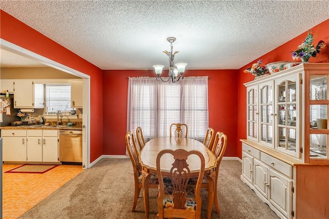 dining area featuring light colored carpet, a notable chandelier, a textured ceiling, and baseboards