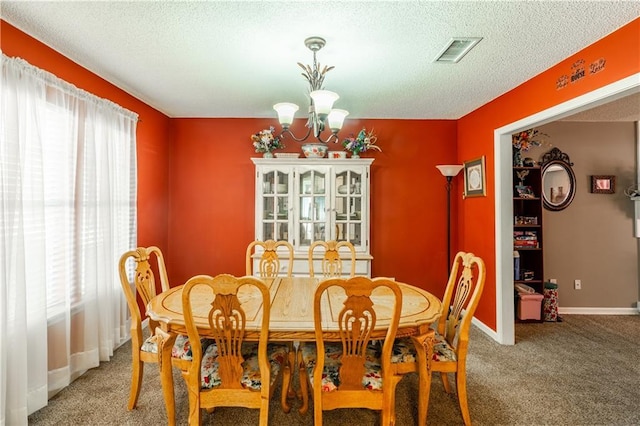 dining room with light colored carpet, a wealth of natural light, visible vents, and an inviting chandelier