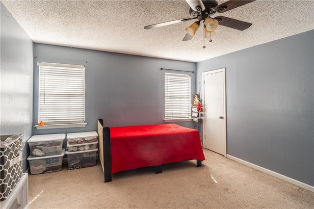 bedroom with a textured ceiling, baseboards, and carpet flooring