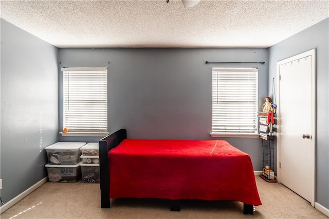 carpeted bedroom with a textured ceiling and baseboards