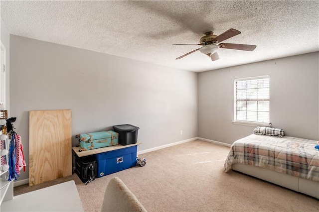 bedroom with ceiling fan, carpet floors, a textured ceiling, and baseboards