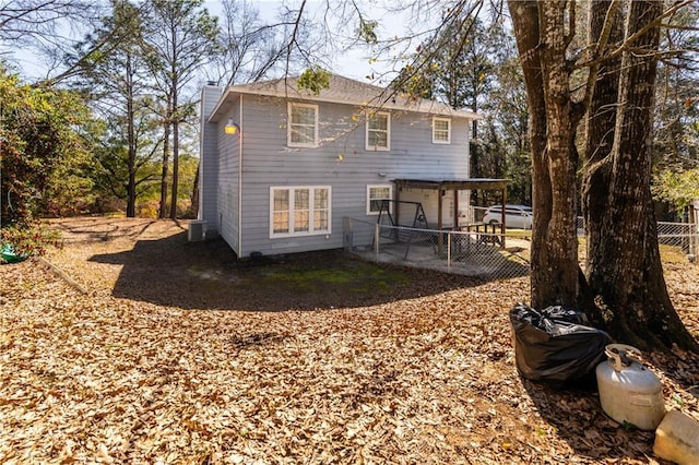 back of property featuring a chimney, fence, and central AC unit