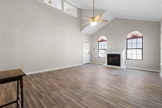 unfurnished living room featuring high vaulted ceiling, dark hardwood / wood-style floors, and ceiling fan