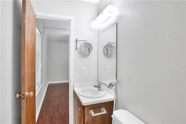 bathroom with hardwood / wood-style floors, vanity, and toilet