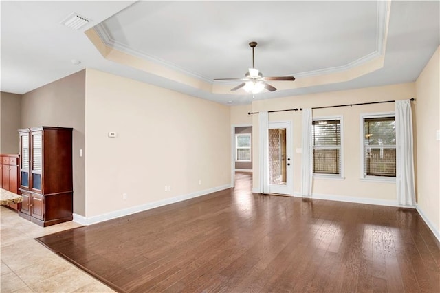 unfurnished room featuring ceiling fan, light hardwood / wood-style floors, crown molding, and a tray ceiling