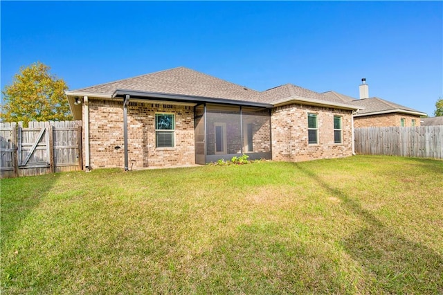 rear view of property featuring a lawn