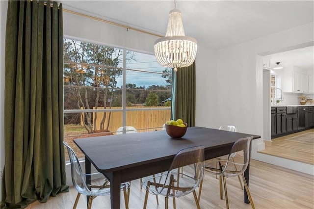 dining room with an inviting chandelier and light hardwood / wood-style flooring