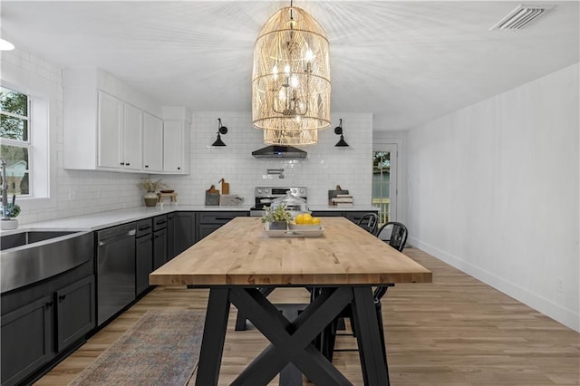 kitchen featuring tasteful backsplash, light wood-type flooring, appliances with stainless steel finishes, pendant lighting, and white cabinets