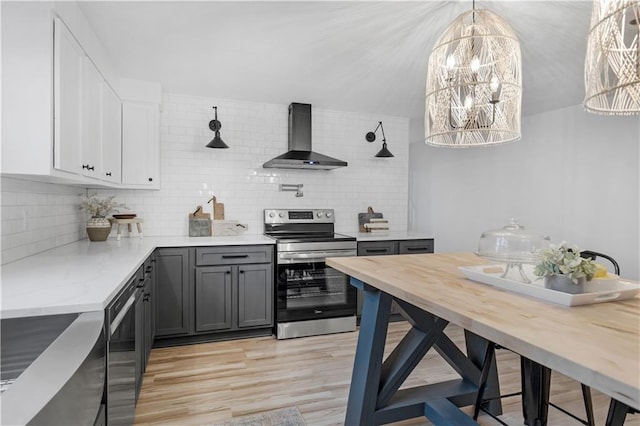 kitchen featuring electric stove, wall chimney range hood, white cabinetry, gray cabinetry, and black dishwasher