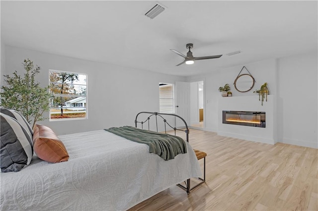 bedroom with light hardwood / wood-style flooring and ceiling fan