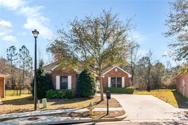 6601 Somerby Ln, Mobile, AL 36695 - view of front facade featuring concrete driveway, brick siding, a front lawn, and fence