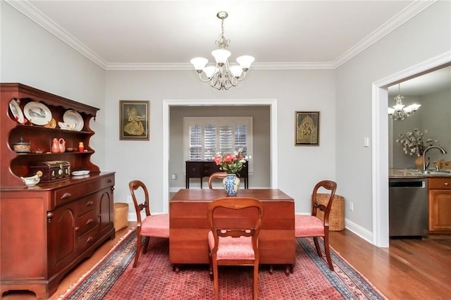 dining space with baseboards, crown molding, a chandelier, and wood finished floors