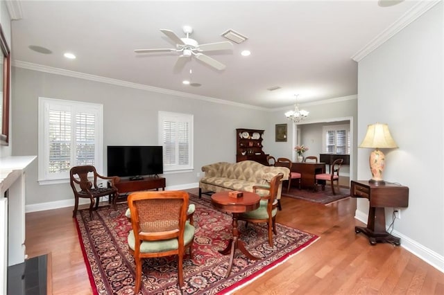 living room featuring baseboards, visible vents, ornamental molding, and wood finished floors