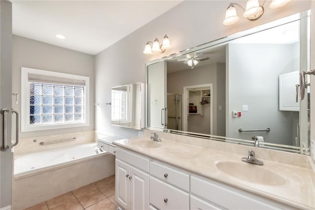 bathroom with double vanity, a garden tub, tile patterned flooring, and a sink