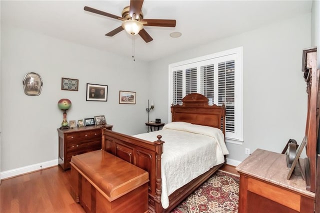 bedroom with ceiling fan, baseboards, and wood finished floors