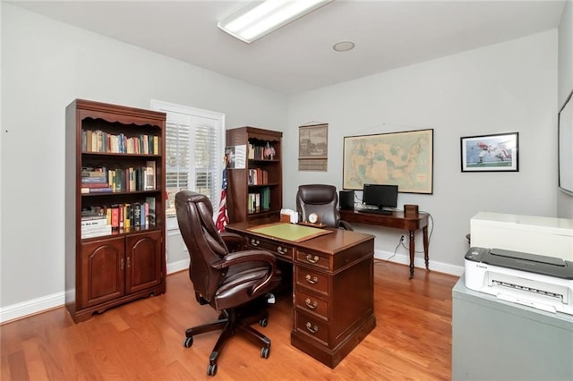 office area featuring light wood-type flooring and baseboards