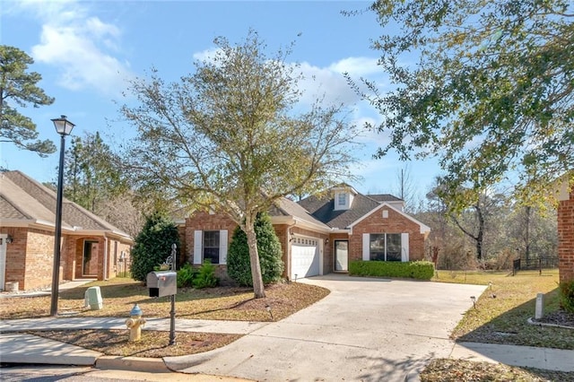 view of front of home with an attached garage, driveway, a front yard, and brick siding