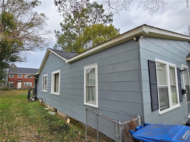 view of property exterior with a yard, crawl space, and fence