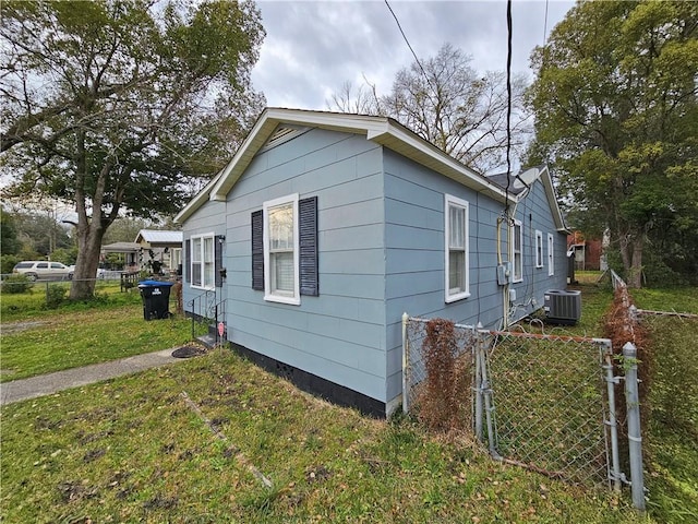 view of property exterior featuring a yard, fence, and central air condition unit