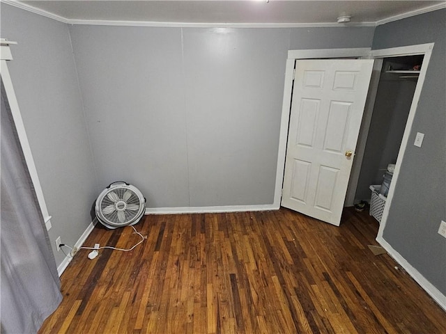 unfurnished bedroom with crown molding, baseboards, and wood finished floors