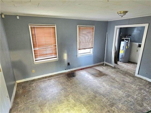 empty room with crown molding, electric water heater, and baseboards