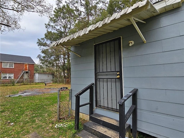 property entrance with a yard and fence