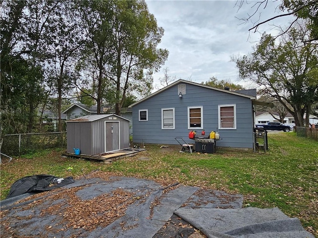 back of property featuring an outbuilding, a fenced backyard, a lawn, and a storage unit