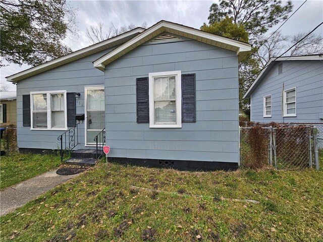 bungalow-style home featuring fence and a front lawn