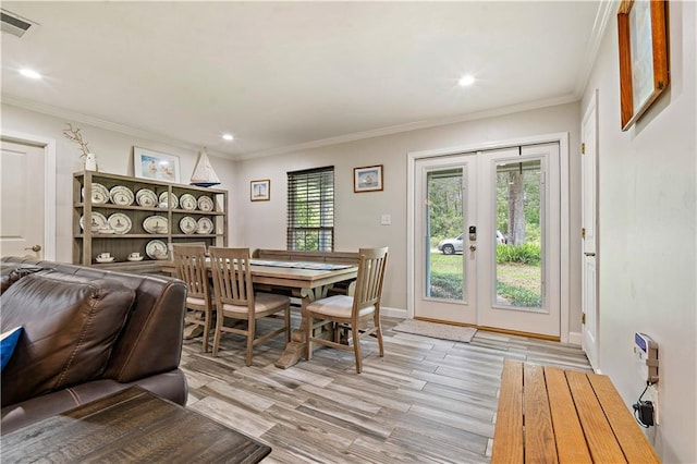 dining area with french doors, light hardwood / wood-style floors, and crown molding