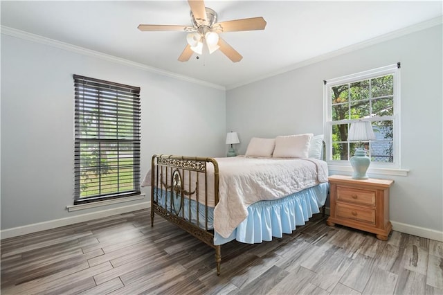 bedroom featuring hardwood / wood-style floors, ornamental molding, ceiling fan, and multiple windows