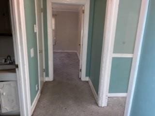 hall with baseboards and carpet