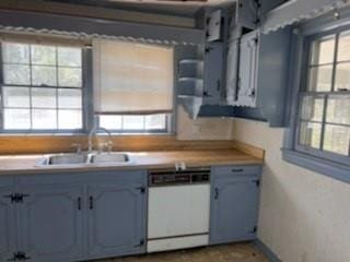 kitchen featuring a sink, white dishwasher, and light countertops