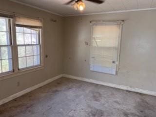 unfurnished room with crown molding, a healthy amount of sunlight, and baseboards