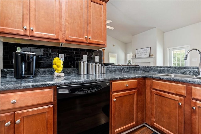 kitchen featuring tasteful backsplash, dark stone counters, black dishwasher, and sink