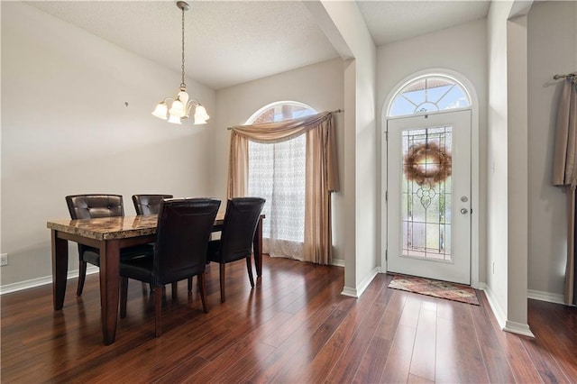 dining room with dark wood-type flooring and a notable chandelier