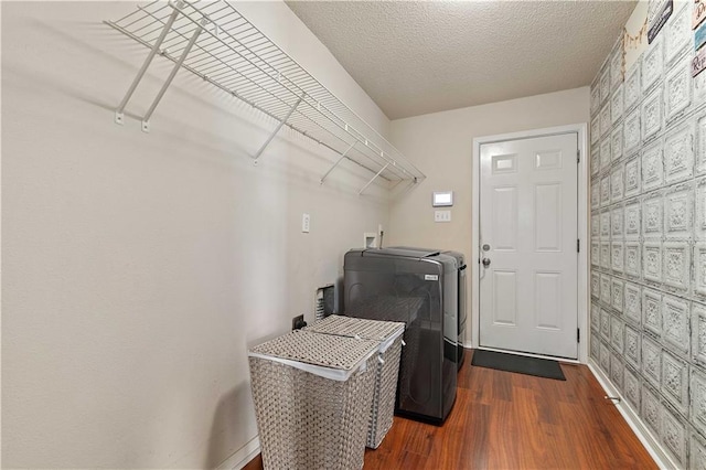 laundry area featuring washer / clothes dryer, a textured ceiling, and dark hardwood / wood-style flooring