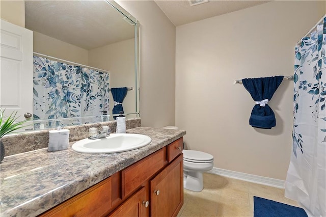 bathroom featuring vanity, tile patterned floors, and toilet