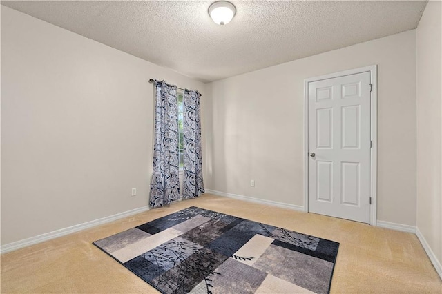 unfurnished room with a textured ceiling and carpet flooring