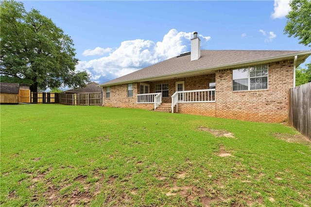 rear view of house featuring a yard