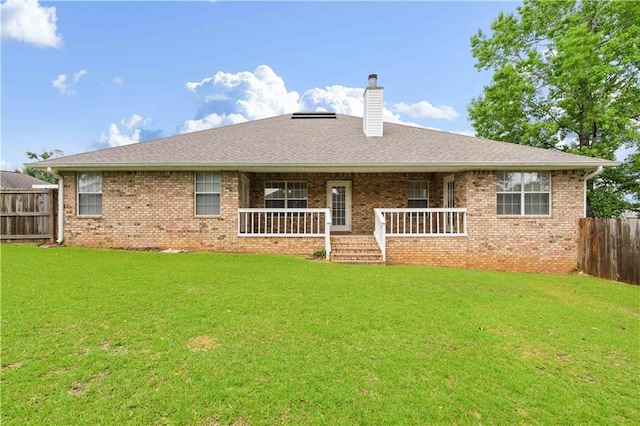 back of house featuring a yard and covered porch